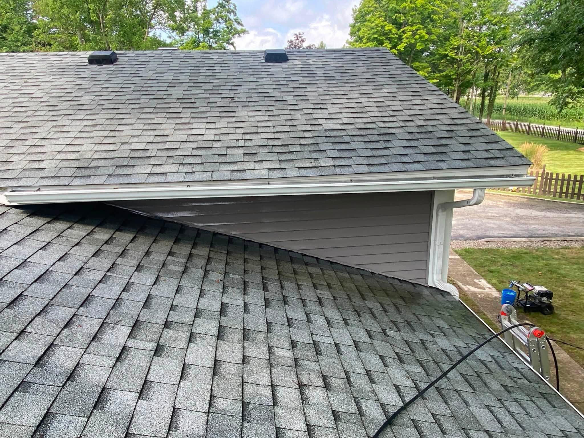 The same roof and gutter line after a soft wash, the shingles even and the gutters bright white