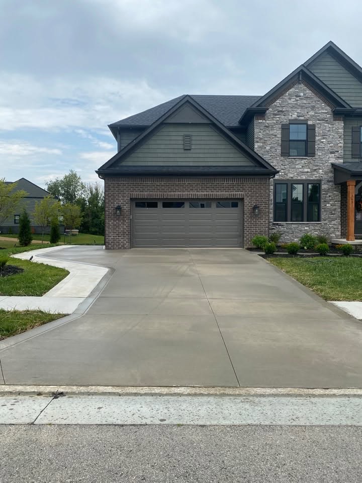 The same driveway after a light clean and a coat of penetrating sealer, the concrete even and slightly darker while it cures